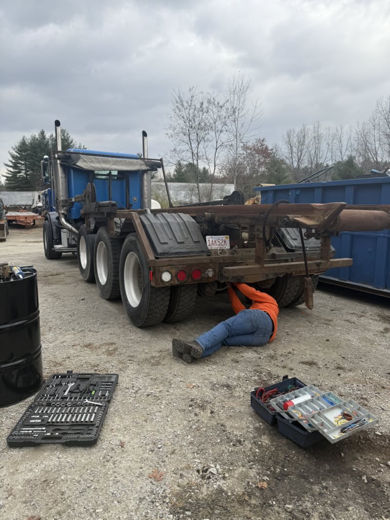 Maintenance work underneath a roll-off truck